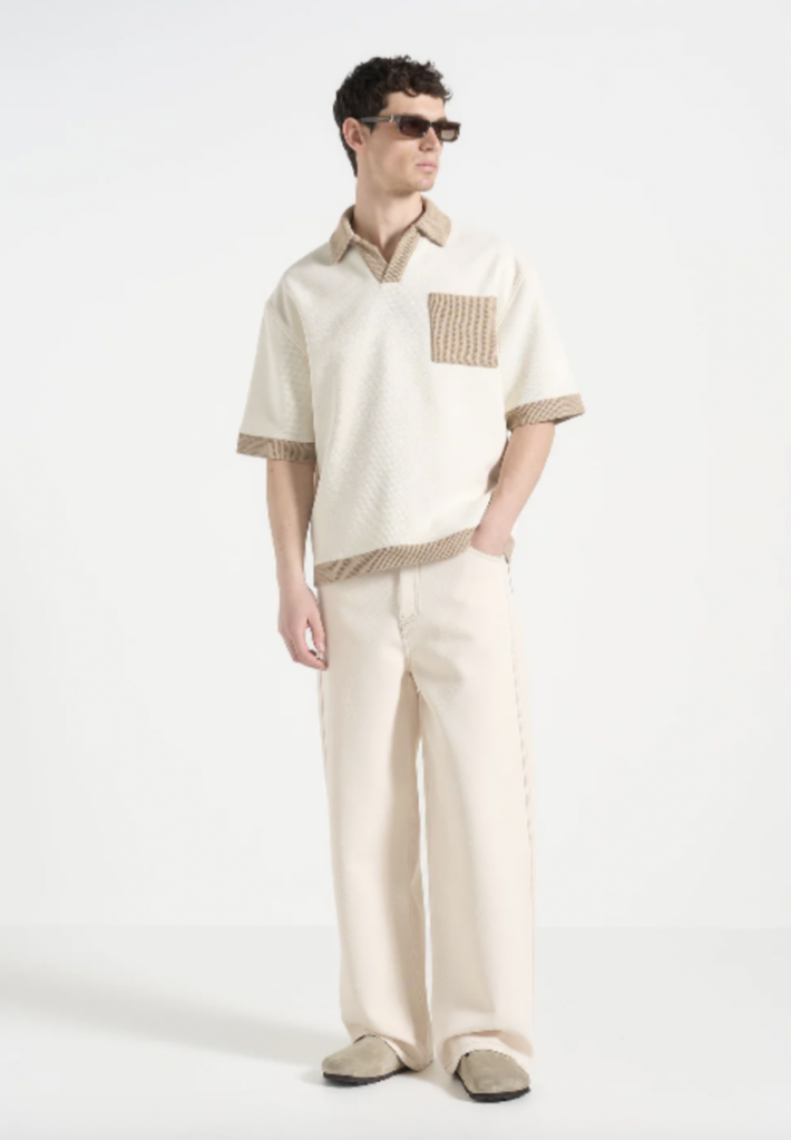 Un polo revisité dans une version texturée aux détails élégants. Parfait mélange entre confort décontracté et allure rétro.
