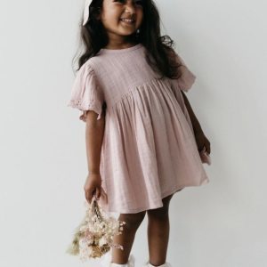 Légère, délicate et poétique, cette robe rose poudré à manches courtes est confectionnée en double gaze de coton biologique, une matière douce.