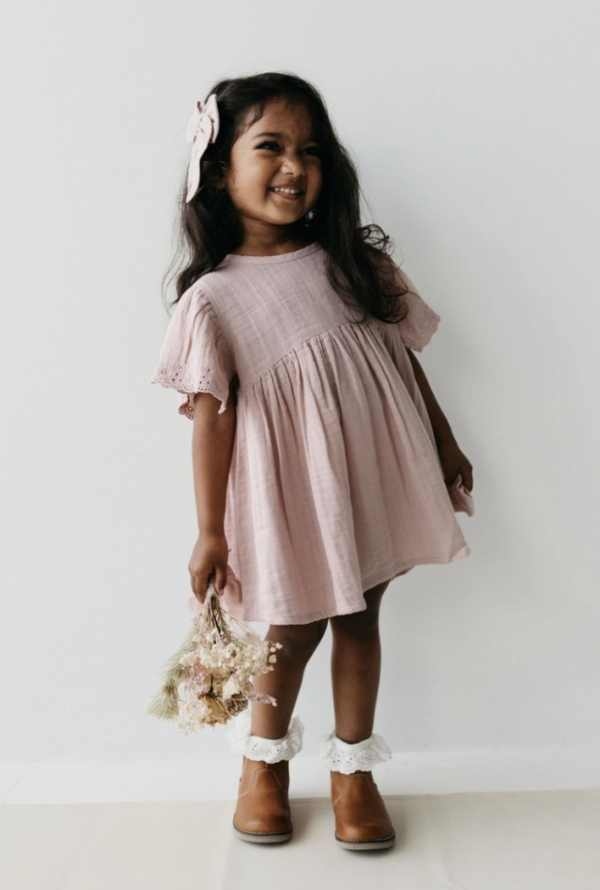 Légère, délicate et poétique, cette robe rose poudré à manches courtes est confectionnée en double gaze de coton biologique, une matière douce.